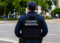 Agente da Guarda Municipal de costas em via pública durante patrulhamento.