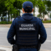 Agente da Guarda Municipal de costas em via pública durante patrulhamento.