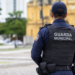 Guarda Municipal de costas com identificação no colete, representando concurso com 100 vagas e salário de até R$ 13.747,02.