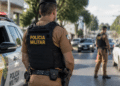 Policial militar atuando em operação de patrulhamento urbano durante fiscalização de trânsito.