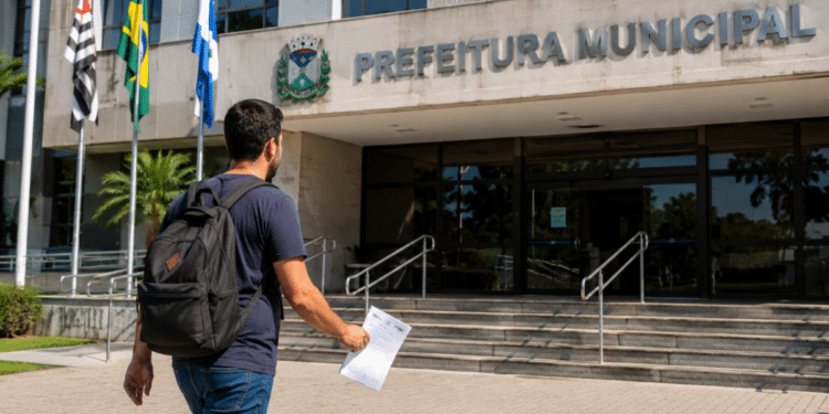 Candidato caminha em direção à Prefeitura Municipal segurando documento de concurso público.