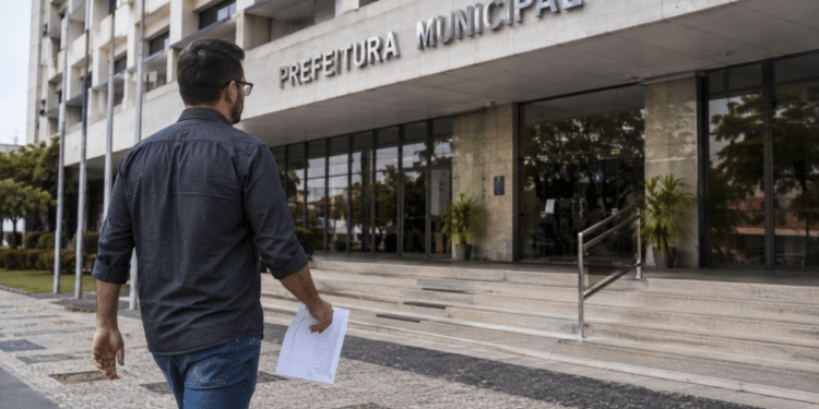 Homem caminhando em direção à prefeitura municipal segurando documento de concurso público.