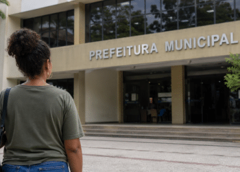 Pessoa em frente à prefeitura municipal simbolizando inscrição em concurso da Prefeitura com salário de até R$ 5 mil.