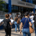 Candidatos com documentos de concurso caminham em direção a uma Câmara Municipal.