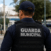 Guarda municipal fardado de costas em área urbana simbolizando segurança pública.