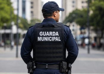 Guarda municipal fardado de costas com identificação Guarda Municipal no colete.