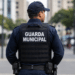 Guarda municipal fardado de costas com identificação Guarda Municipal no colete.