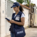 Profissional do IBGE em trabalho de campo durante coleta de informações em rua residencial.