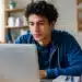 Jovem estudante brasileiro consultando vagas do Sisu+ 2026 em notebook durante rotina de estudos