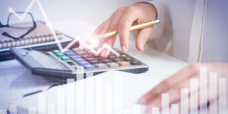 Analista financeiro e contador avaliando gráficos de desempenho em tela digital, representando gestão e crescimento de pequenas empresas.