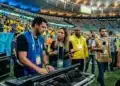 Profissionais nos bastidores da Copa do Mundo ajustando equipamentos de som e coordenando a transmissão do evento.