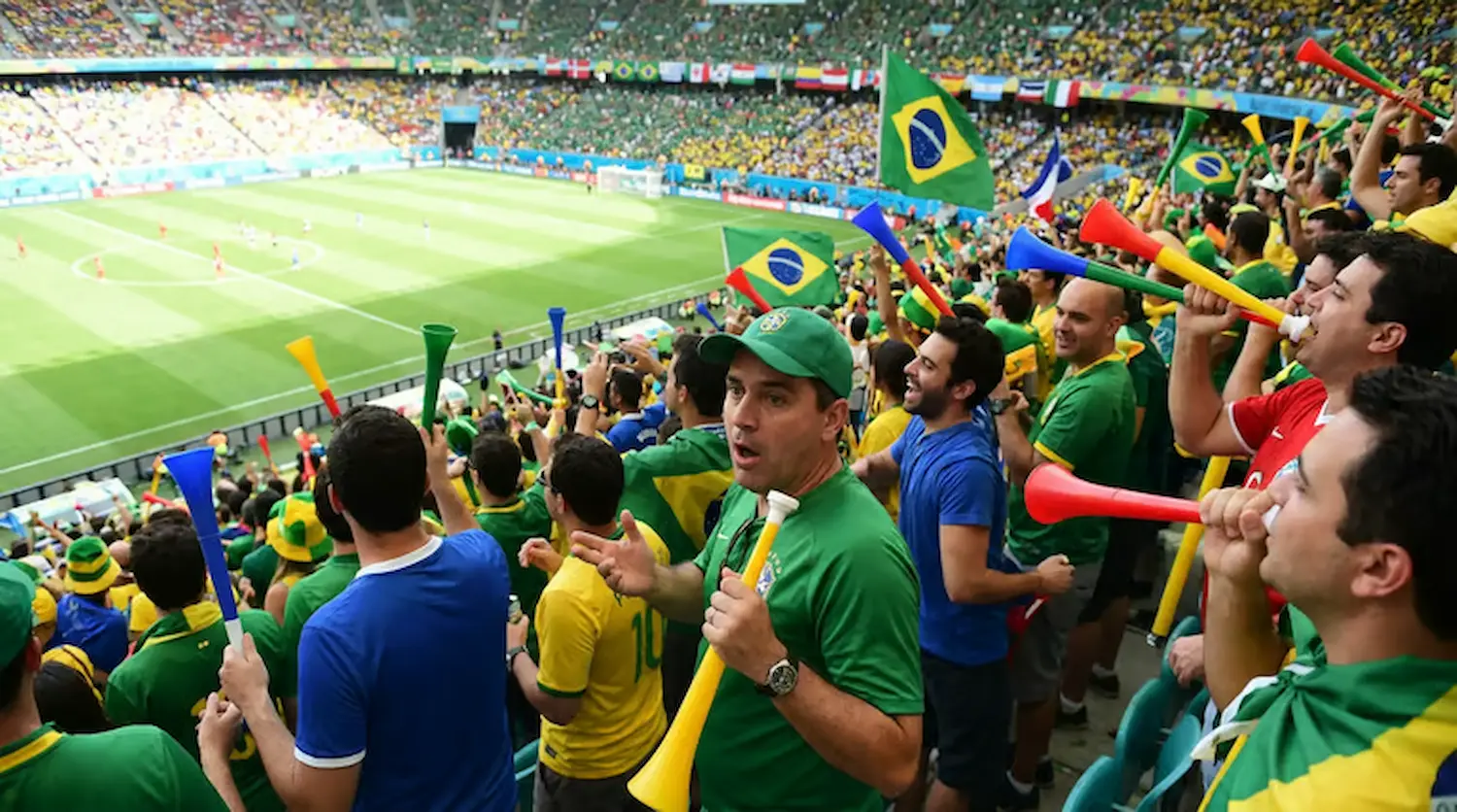 Torcida brasileira em estádio com vuvuzelas, antes da proibição da FIFA na Copa do Mundo de 2026.