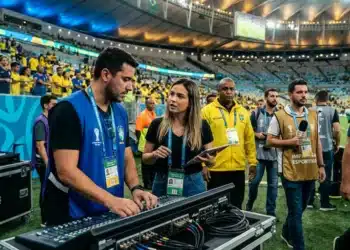 Profissionais nos bastidores da Copa do Mundo ajustando equipamentos de som e coordenando a transmissão do evento.