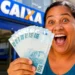 Mulher sorridente segura cédulas de real em frente a uma agência da Caixa, representando o depósito de R$ 1.621 na próxima semana.