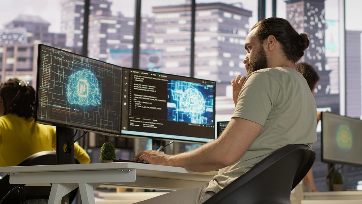 Desenvolvedor analisa rede neural em múltiplos monitores, cenário que ilustra o alerta da Anthropic sobre desacelerar o avanço da inteligência artificial