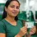 Mulher em unidade de atendimento segurando documento de identidade, representando a ação de emissão da segunda via do RG
