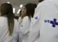 Profissionais da saúde com jaleco do SUS durante ambiente de formação e residência médica.
