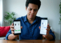 Homem compara preços e modelos de celular segurando dois smartphones, um em cada mão