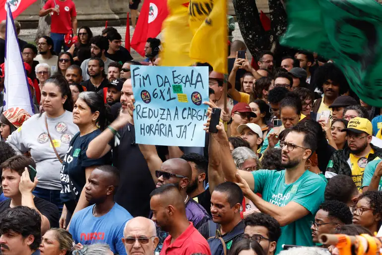 Ato de manifestantes pelo fim da escala 6x1, com faixa em defesa de vida além do trabalho.