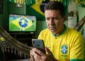 Torcedor brasileiro acompanha notícias no celular durante clima de alerta para golpes ligados à Copa de 2026.