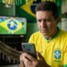 Torcedor brasileiro acompanha notícias no celular durante clima de alerta para golpes ligados à Copa de 2026.