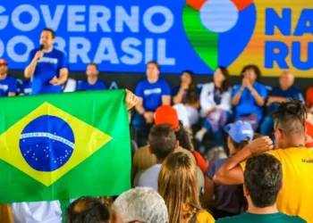 Público acompanha ação do Governo do Brasil na Rua com bandeira do Brasil em destaque durante mutirão de serviços federais.