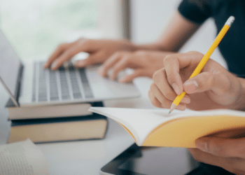 Pessoa estudando para concurso público com notebook e material de apoio, representando a preparação para o concurso da Prefeitura de Boa Esperança do Iguaçu (PR).
