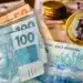 Cédulas de real e moeda simbolizando pagamento de benefícios do INSS para aposentados e pensionistas.
