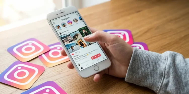 Pessoa usando o Instagram em um celular sobre uma mesa com ícones da rede social, em contexto de debate sobre localização em tempo real e proteção de dados.