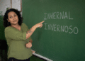 Professora em sala de aula apontando para lousa com as palavras invernal e invernoso escritas em giz.