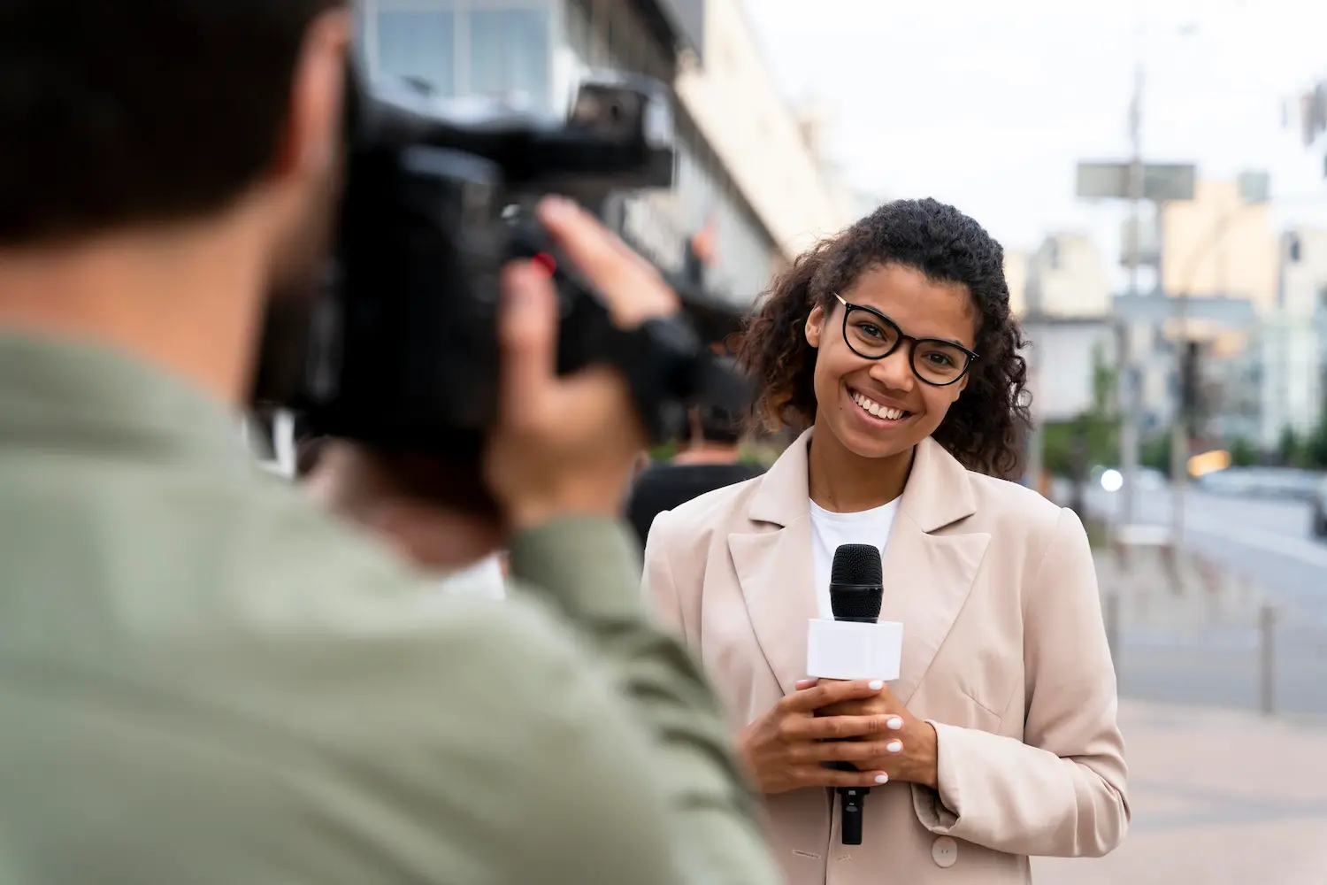 Profissões que exigem trabalho em campo e mobilidade constante Jornalista sendo entrevistada em ambiente urbano durante gravação de reportagem.