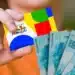 Mão segurando cartão do Bolsa Família com notas de reais ao fundo, ilustrando o pagamento do benefício conforme o NIS nesta quarta-feira (24).
