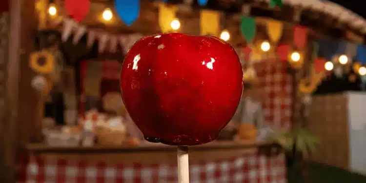 Maçã do amor brilhante em destaque em barraca de festa junina, representando o plural correto do doce típico
