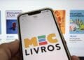 Tela de celular exibe logo do MEC Livros em frente a catálogo online de livros digitais