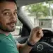 Motorista brasileiro mostrando a CNH dentro do carro, representando a satisfação com a renovação automática da carteira de motorista