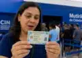 Mulher observando a nova Carteira de Identidade Nacional, representando o mutirão para emissão do documento a partir desta segunda-feira (1º).