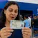 Mulher observando a nova Carteira de Identidade Nacional, representando o mutirão para emissão do documento a partir desta segunda-feira (1º).
