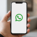 Pessoa segurando smartphone com tela do WhatsApp aberta para criação e reserva de nome de usuário.