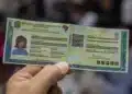 Pessoa segurando a nova Carteira de Identidade Nacional com destaque para o QR Code e elementos de validação digital.