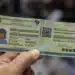 Pessoa segurando a nova Carteira de Identidade Nacional com destaque para o QR Code e elementos de validação digital.
