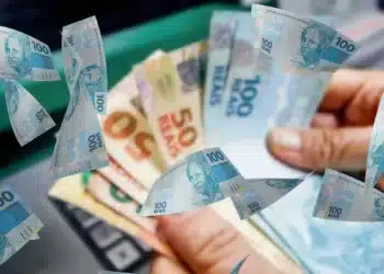 Pessoa segurando notas de real, ilustrando novo saque de R$ 6.220 liberado pela Caixa para quem tem direito ao valor.