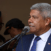 Autoridade pública discursando em cerimônia com presença de integrantes das forças de segurança ao fundo.