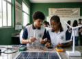 Dois estudantes de escola estadual de MG analisam painel solar com multímetros na Olimpíada de Eficiência Energética 2026.