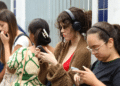 Estudantes consultam o celular do lado de fora do local de prova do Enem encostados na parede
