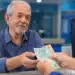 Idoso recebendo pagamento em agência do INSS, representando pagamentos no teto de R$ 8.475,55 liberados nesta semana.