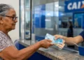Pessoa idosa recebendo dinheiro em banco, representando o pagamento do BPC em junho de 2026.