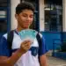 Estudante do ensino médio segurando dinheiro, simbolizando o recebimento do incentivo de R$ 1.000 do Pé-de-Meia até 6 de julho.