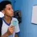 Estudante brasileiro conferindo o calendário e segurando dinheiro, ilustrando o depósito do benefício Pé-de-Meia em junho.