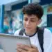 Estudante brasileiro em uniforme escolar olhando para um calendário, representando a consulta às datas de pagamento do programa em junho de 2026.