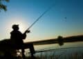 Pescador lança a vara à beira da água ao entardecer, retratando os pescadores do semiárido